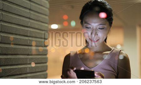 Woman using cellphone in restaurant with window reflection