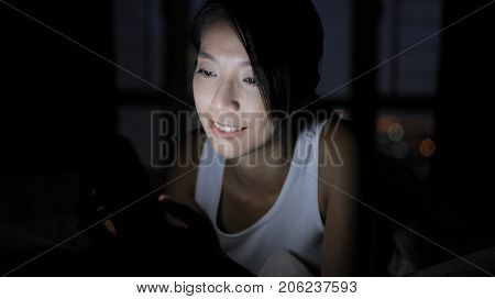 Woman using smart phone at home and lying on bed