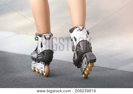 Legs of young woman rollerskating outdoors
