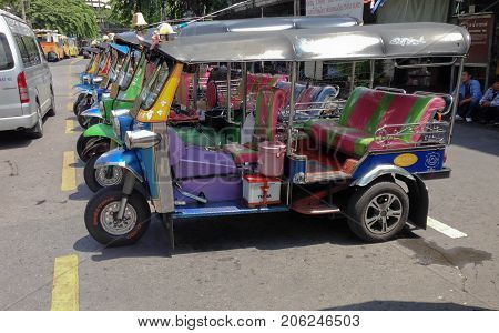 BANGKOK THAILAND - SEPTEMBER 27 2017:The three wheeled tuk tuk taxi wait passenger on a street in the Thai capital on September 27 2017 in Bangkok Thailand. Tuk tuks are commonly used in transporting people.