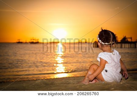 BORACAY, PHILIPHINES- MARCH 17, 2017: Baby gazing on the sunset at White beach ,  Boracay island on March 17, 2017. Philiphines.