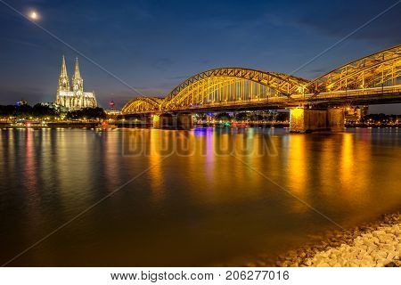 Night View of Cologne Cathedral (Kolner Dom) and Rhine river under the Hohenzollern Bridge, Cologne city skyline at night, North Rhine Westphalia region, Germany.
