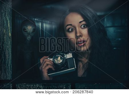 Woman with photocamera and alien behind her