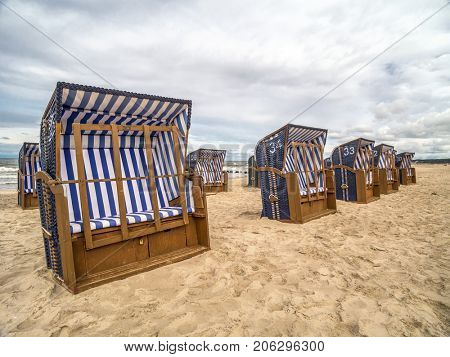 Empty roofed wicker beach chairs on sandy beach in Ustka resort, Baltic sea, Poland  clear sign that summer is over