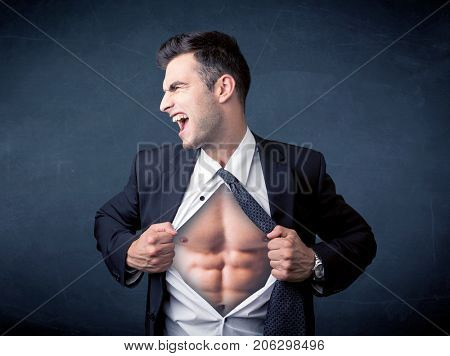 Businessman tearing off his shirt and showing mucular body concept on background