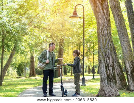 Portrait of father with his son walking together in autumn park. Family leisure. Parenting. Parenthood.