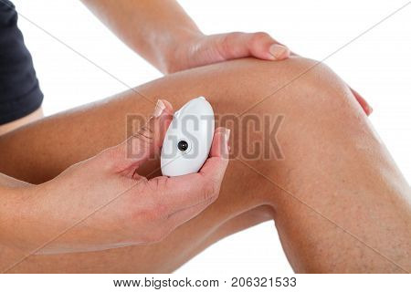 Close up picture of young woman epilating legs spider veins because of hormonal change - isolated