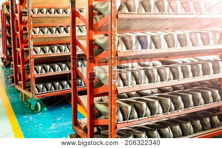 Lines of aluminum last shoes with a rough surface prepare on shelf in a shoe factory.