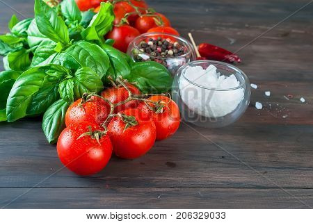 Tomatoes And Bunch Of Fresh Green Basil On A Dark Wood Background,