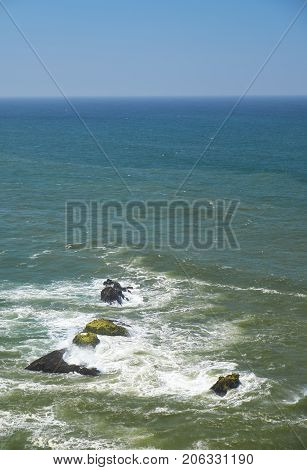 Rocks And Waves Of Surf In The Ocean Near Farol De Nazare Coast In Portugal