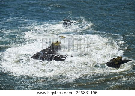 Rocks And Waves Of Surf In The Ocean Near Farol De Nazare Coast In Portugal