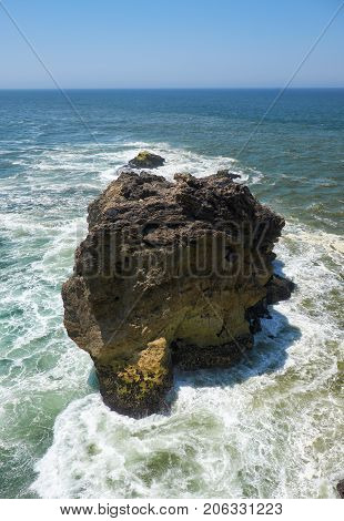 Rocks And Waves Of Surf In The Ocean Near Farol De Nazare Coast In Portugal