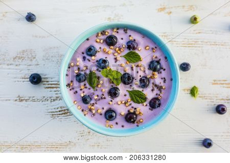 A bowl of healthy and delicious blueberry smoothie with grains and fresh fruit.