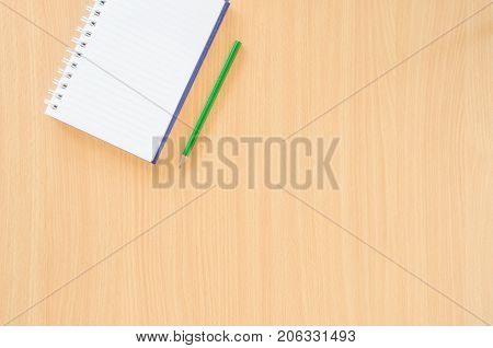 Note Book And Green Pencil On Beech Color Background With Copy Spech.