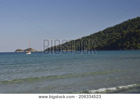 Small boat out on the sea with blue clear water and blue skypicture from Thassos Island Greece.