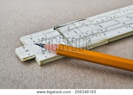 Closeup of a mathematical slide rule and yellow pencil