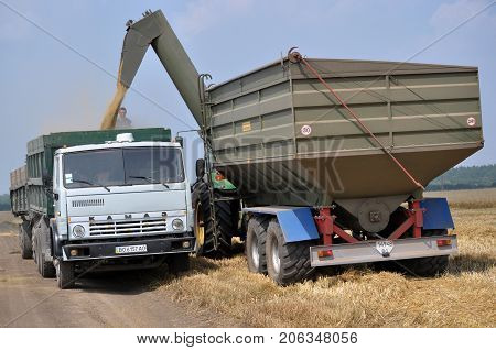 Chortkiv - Ternopil - Ukraine - July 26 2016. Unloading grain from hopper-conveyors on truck at the edge of the field in the agricultural firm 