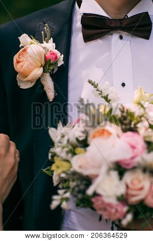 Wedding flowers bouquet and buttoniere in bride and groom hand