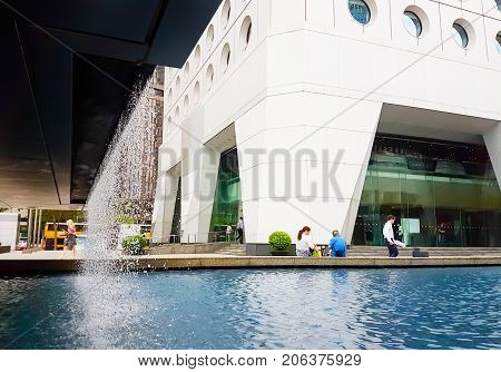 HONG KONG ASIA - SEPTEMBER 20 2017; Jardine House 1 Connaught Place Central Hong Kong with water feature at base being enjoyed by people, mobile phone image.