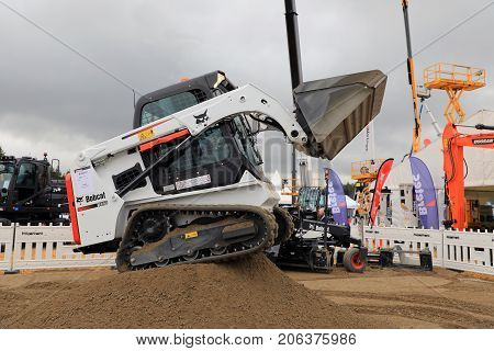 HYVINKAA FINLAND - SEPTEMBER 8 2017: Operator works with Bobcat T450 Compact Track Loader on sand work site on Maxpo 2017.