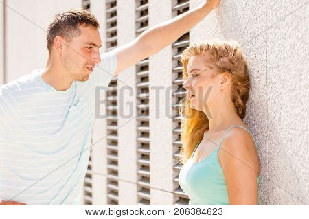 Flirt love and passion concept. Man flirting with attractive blone girl on city street.