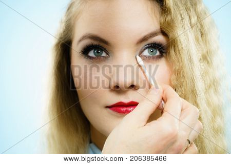 Professional artist fixing fashion model make up using ear buds cotton tipped swabs q tip