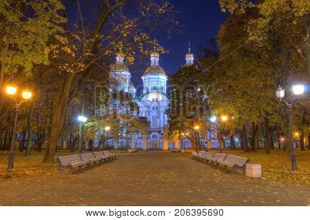 Night autumn view of illuminated St. Nicholas Naval Cathedral and alley in Nikolskiy garden St. Petersburg Russia