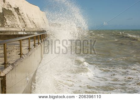Rough sea with waves crashing onto seafront promenade at Rottingdean near Brighton East Sussex England
