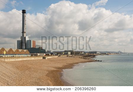 Seafront at Shoreham in West Sussex England with industrial units and power station on harbour and port complex. Brighton in distance.