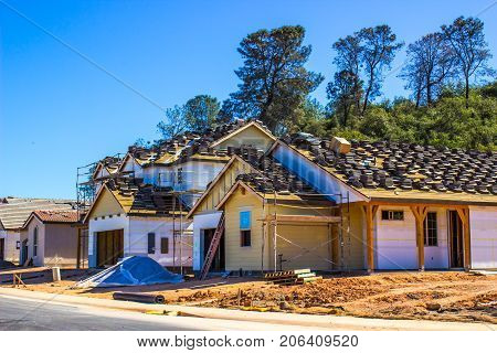 New Homes Under Construction With Materials On Roof