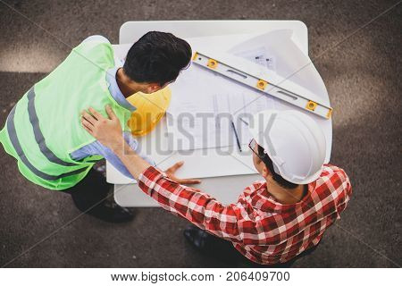 View of an Engineer and worker checking plan on construction site. Top view Construction Concept