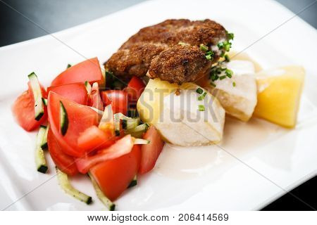 Minced meat cutlet with boiled potatoes and tomato-cucumber salad