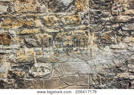 Ancient brick wall with different size of stones, close up photo. Texture or background.
