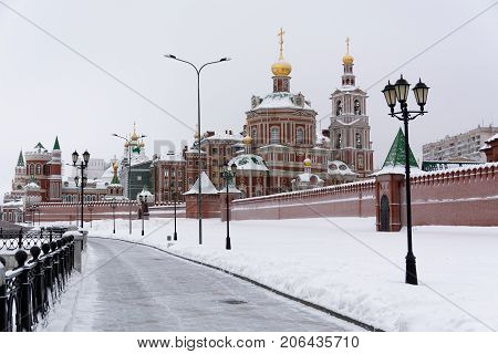 View of snow-covered houses of red brick on the embankment of the city of Yoshkar-Ola, Russia