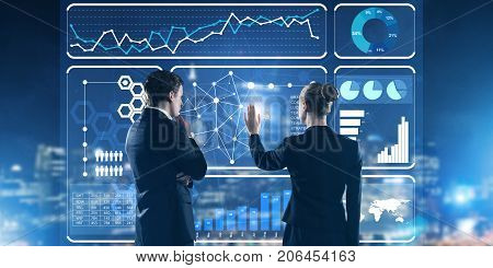 Two business people standing with back and working together with virtual screen