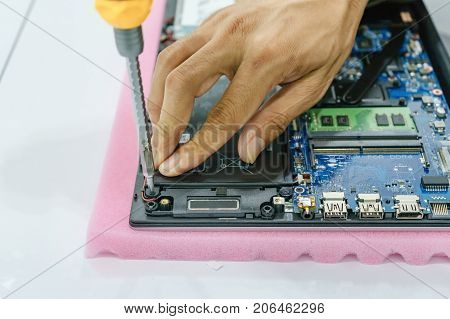 Repairman disassembling laptop motherboard. IT technician repairing broken laptop notebook computer. Electronic repair shop technology renovation business occupation concept