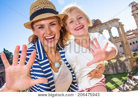 Smiling Mother And Daughter Travellers In Rome Handwaving