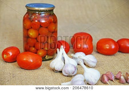 Garlic and tomatoes. Canned tomatoes. Garlic on a background of tomatoes.