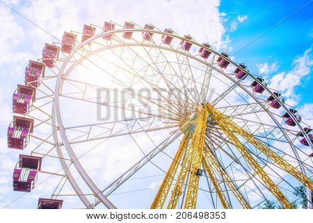 The Ferris wheel on the background of the cloudy sky