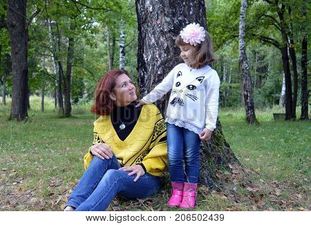 family mom and daughter resting in the forest