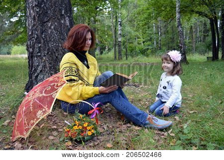 family mom and daughter resting in the forest