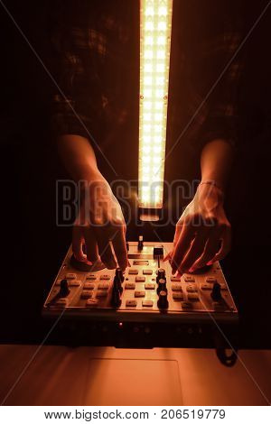 DJ mixer disco illuminated by floodlights at the club