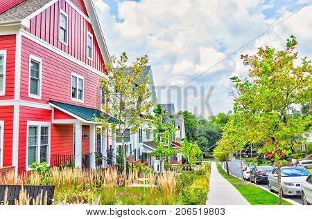 Silver Spring USA - September 16 2017: Colorful multicolored red blue painted residential new townhouses homes houses in Maryland with cars on street in summer
