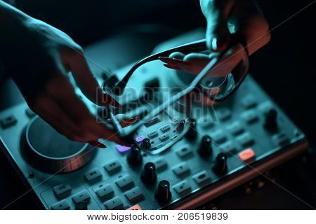 DJ mixer disco illuminated by floodlights at the club