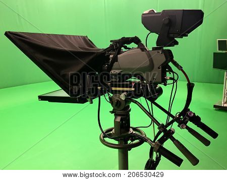 Modern empty green video recording and broadcasting studio with tv channel led screen and metalic stands, text prompter