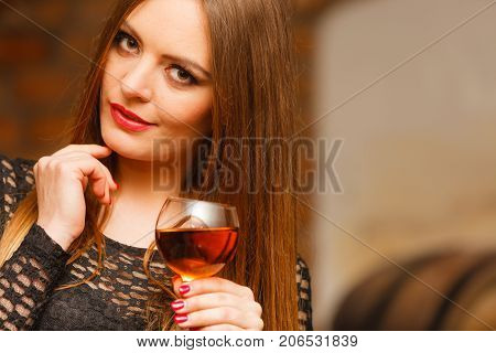 Woman Tasting Wine In Rural Cottage Interior