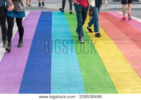 Vancouver British Columbia Canada - 12 September 2017: Gay pride flag crosswalk in Vancouver gay village with people crossing