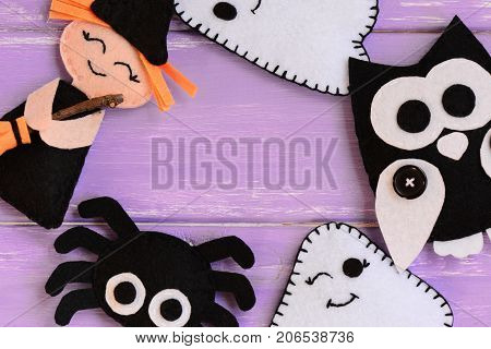 Quick Halloween crafts. Felt witch, ghosts, owl, spider decor on a wooden table. Felt Halloween handmade decor set. Easy sewing pattern for adults and kids. Top view