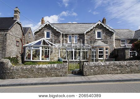 Tintagel, Cornwall, UK: April 14, 2014: A traditionally built, double fronted stone house with two added conservatories. A beautiful example of the characteristic houses in rural Cornwall.