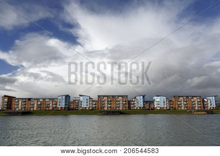 Quayside Apartment Building on reclaimed land with a dramatic cloudscape.